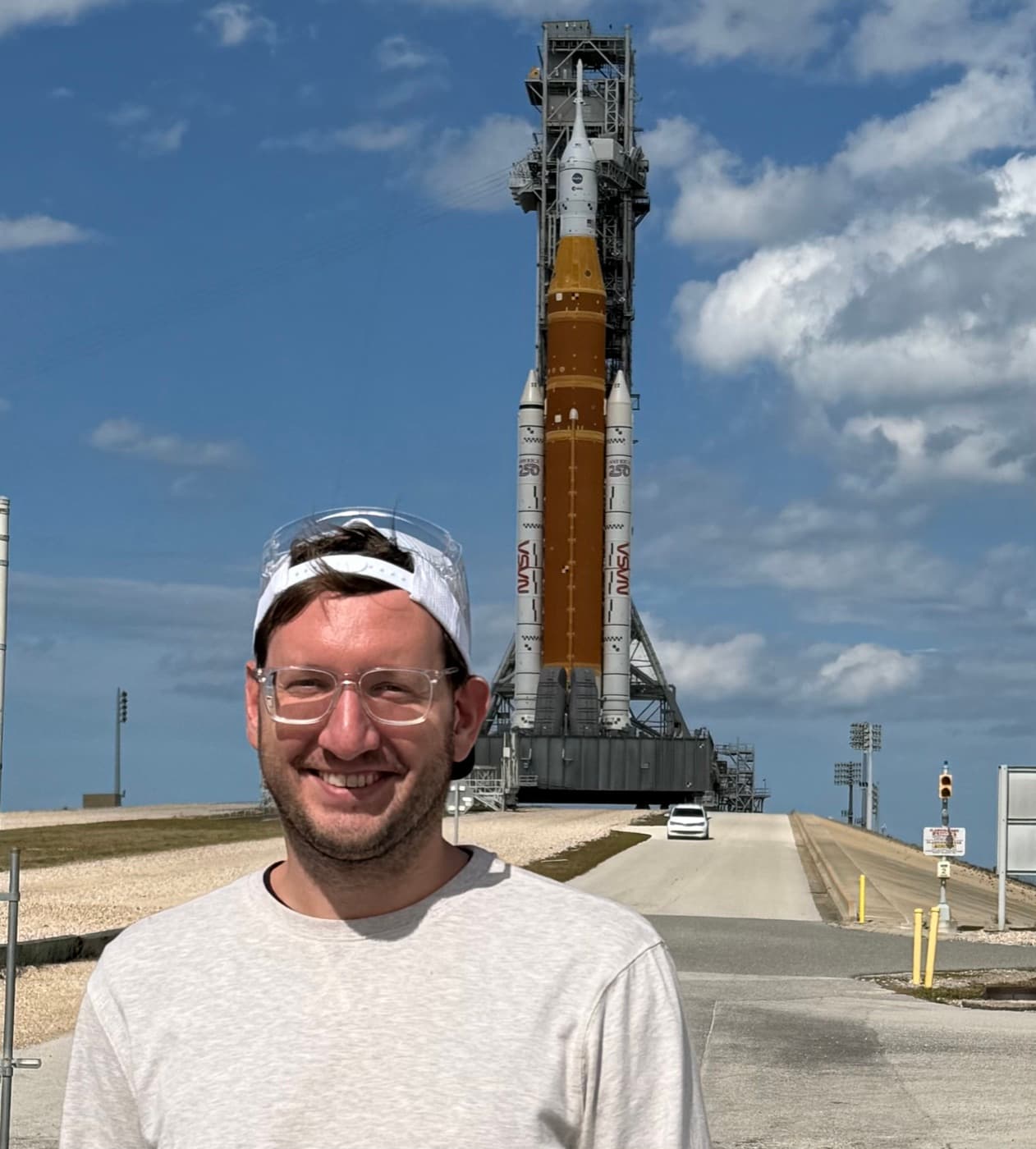 Brian Wojcik in front of a rocket on the launch pad at Kennedy Space Center